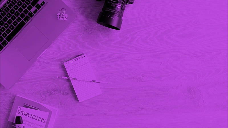 Digital Storytelling - begeistert eure Kunden! | Online Marketing und Social Media Agentur Ein Bild von einem Laptop neben dem ein Buch zu Storytelling, ein Notizblock mit einem Stift und eine Kamera liegt