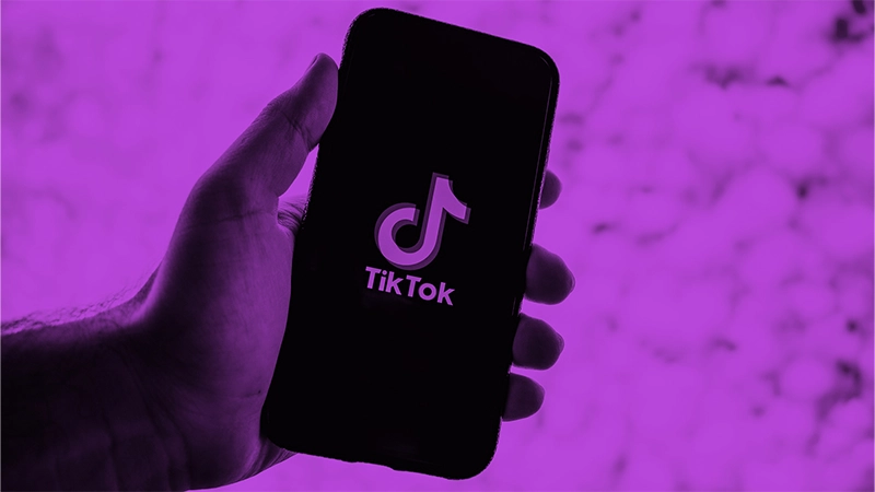 Das Phänomen TikTok und seine spannenden Erfolgskriterien | Online Marketing und Social Media Agentur Eine Hand hält ein Handy mit dem Wort und Bild Logo von TikTok auf dem Bildschirm