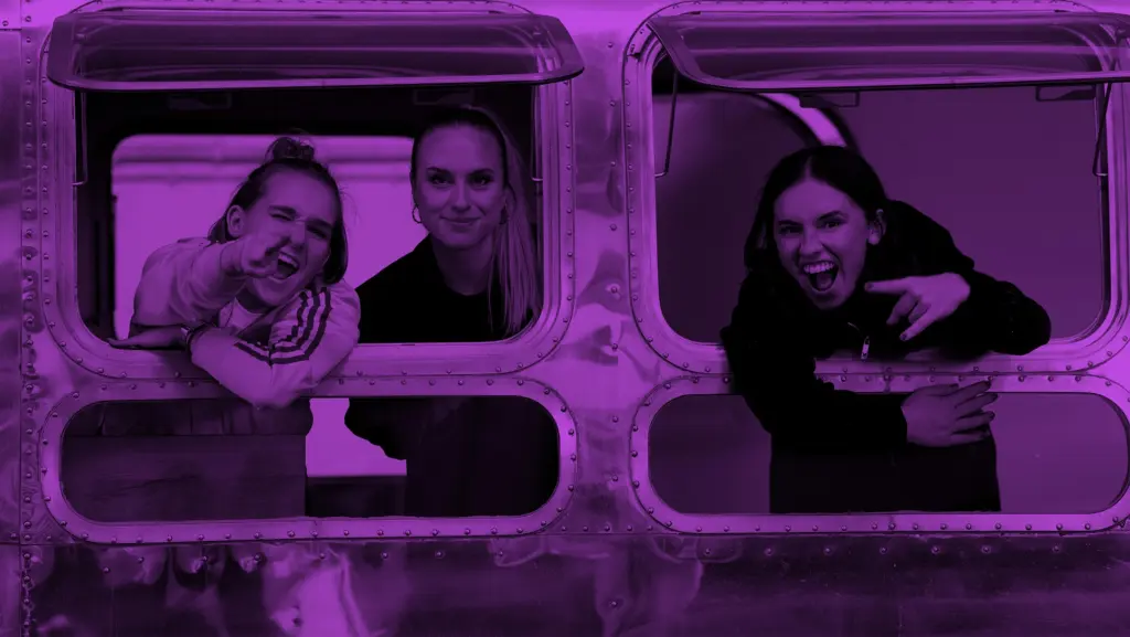 YouTube Marketing: Der ultimative Leitfaden für mehr Reichweite, Abonnenten und Umsatz | Online Marketing und Social Media Agentur Drei Frauen schauen auf den Fenstern eines Airstreams